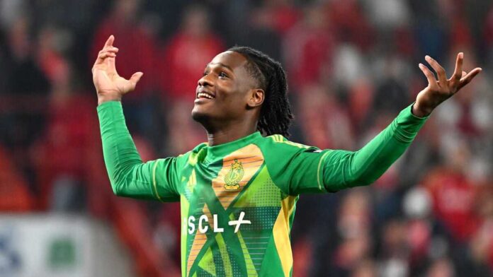 Gardien de football en tenue rouge dans un stade, portant des gants, debout devant les buts