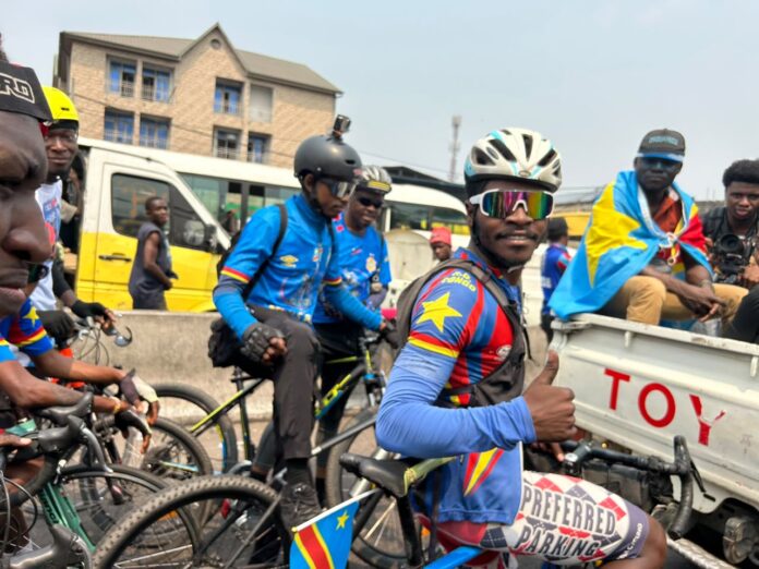 Bicyclette avec drapeau de paix et couleurs congolaises sur une route de Kinshasa
