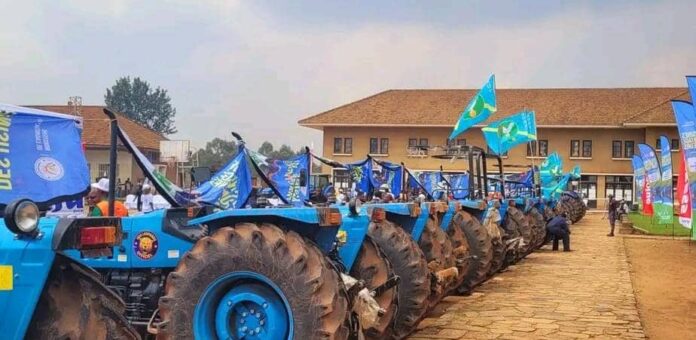 Tracteurs agricoles alignés lors d'une cérémonie à Butembo, avec des agriculteurs en arrière-plan