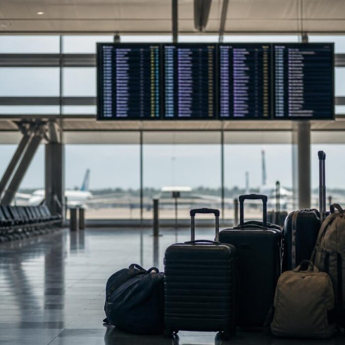 Voyageurs avec bagages dans un aéroport, attendant un vol pour Kinshasa