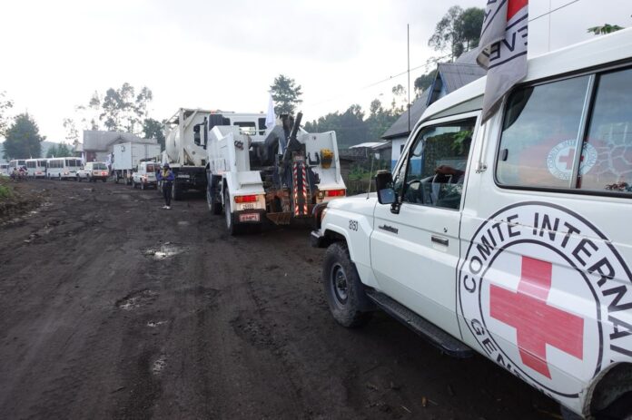 Convoi humanitaire de véhicules blancs sur une route de l'est de la RDC