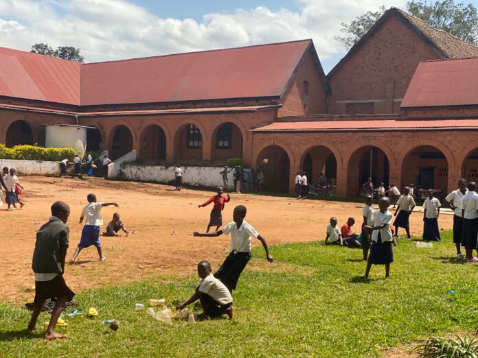 Écoliers se lavant les mains devant une école en Ituri avec un dispositif de prévention contre Ebola
