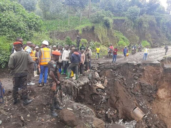 Route en terre fortement dégradée avec des nids-de-poule et des bourbiers, dans une zone rurale au Nord-Kivu