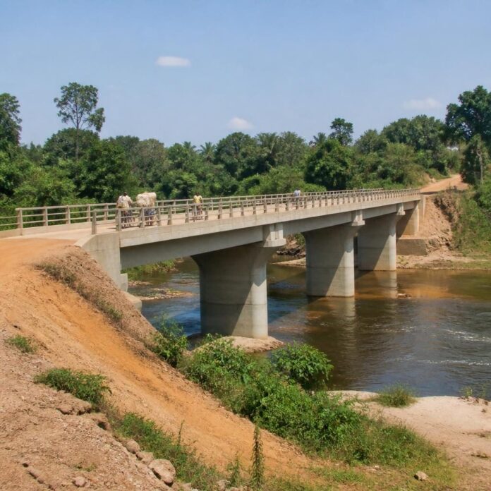 Pont en béton armé enjambant la rivière Lotembo, avec des habitants et des marchandises traversant, dans la région de Katako-Kombe