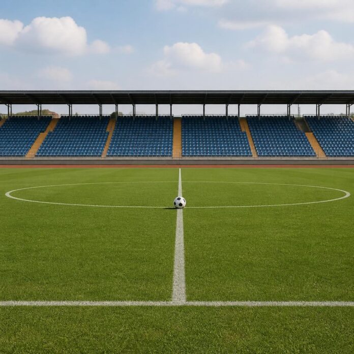 Terrain de football avec ballon au centre dans un stade de Kigali