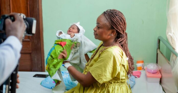Professionnel de santé présentant des comprimés de fer à une femme enceinte lors d'une consultation prénatale