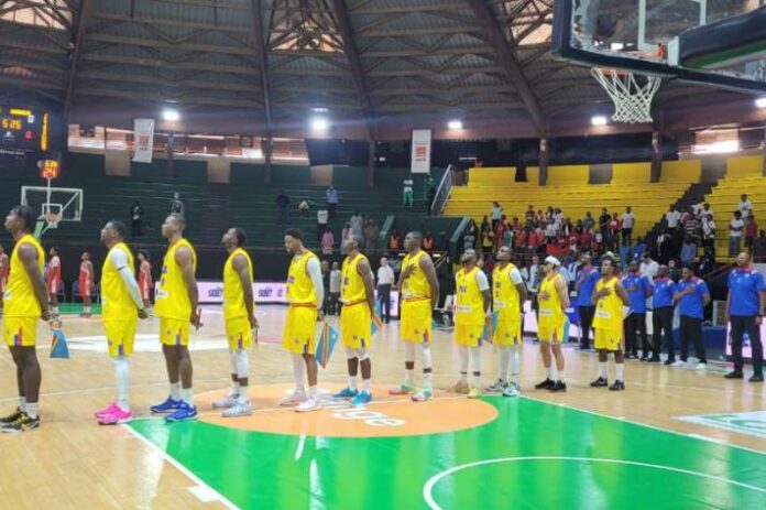 Action de basketball dans une salle moderne avec joueurs en mouvement, ballon en jeu et tableau d'affichage, sans visages identifiables