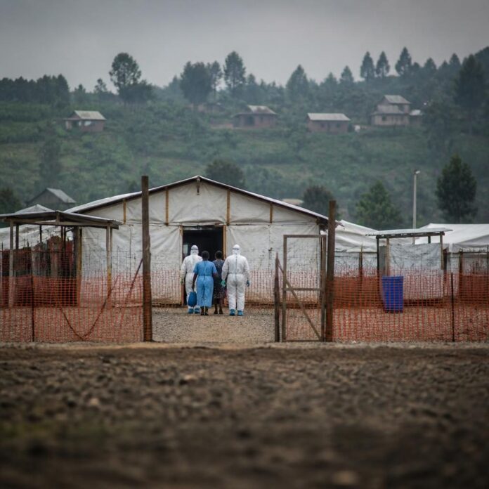 Des patients guéris quittant un centre de traitement d'Ebola à Beni, accompagnés par du personnel soignant en tenue de protection