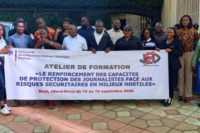 Des journalistes assis dans une salle de formation à Beni, prenant des notes devant un formateur