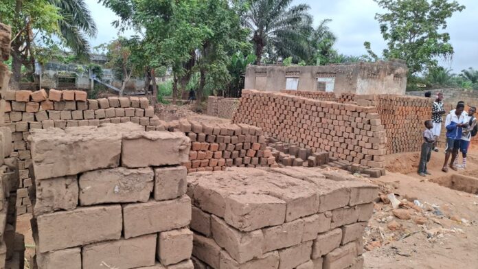 Artisans fabricant des briques cuites sur un site de production à Boma, Kongo-Central