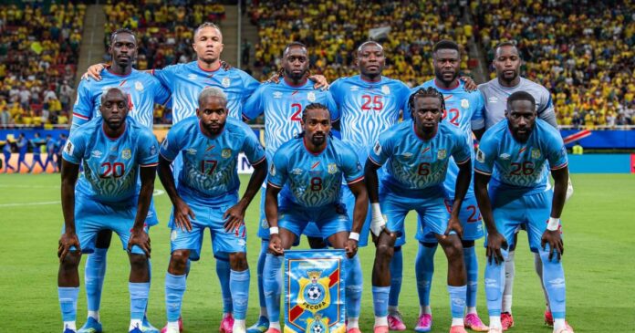 Stade des Martyrs de Kinshasa avec pelouse verte et tribunes prêtes pour un match de football