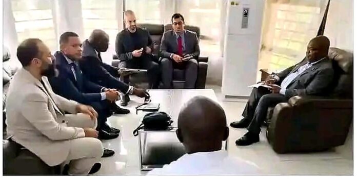 Salle de réunion officielle à Kindu avec documents de projet, cartes et chaises vides