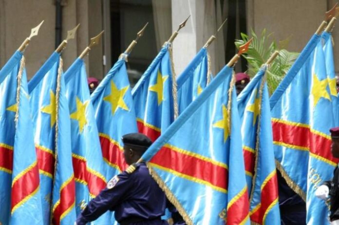 Drapeaux en berne et bougies devant un bâtiment officiel après le crash aérien de Kenge, ambiance de deuil national
