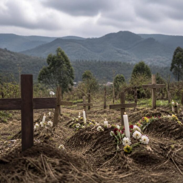 Cimetière rural avec des tombes ornées de fleurs et de bougies dans un village du Nord-Kivu lors de la commémoration des victimes des ADF