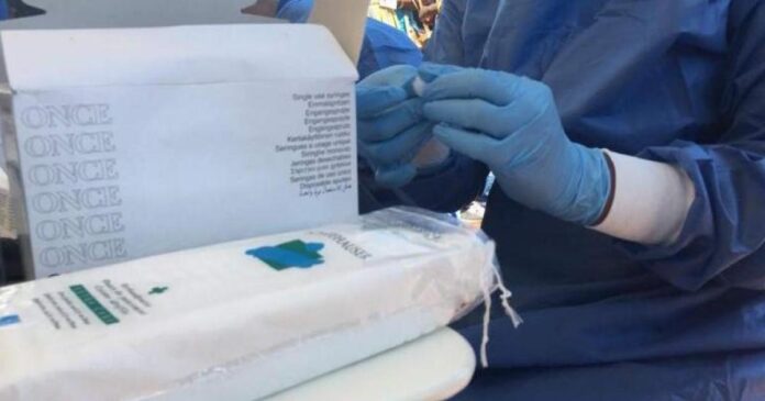 Des agents de santé en tenue de protection devant une structure sanitaire de Katwa, dans un contexte de riposte contre Ebola