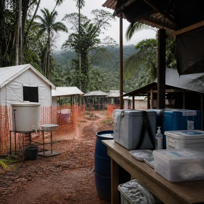 Équipe de riposte en équipement de protection dans une zone touchée par Ebola, avec matériel de désinfection et centre de traitement