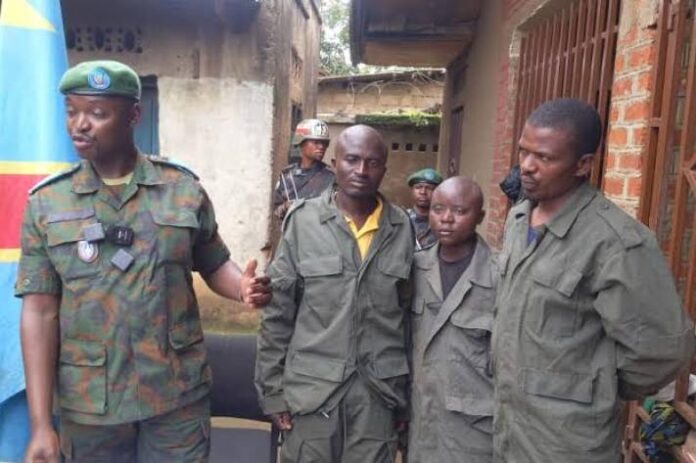 Soldats des FARDC en patrouille sur une piste des Hauts-Plateaux d'Uvira, vus de dos