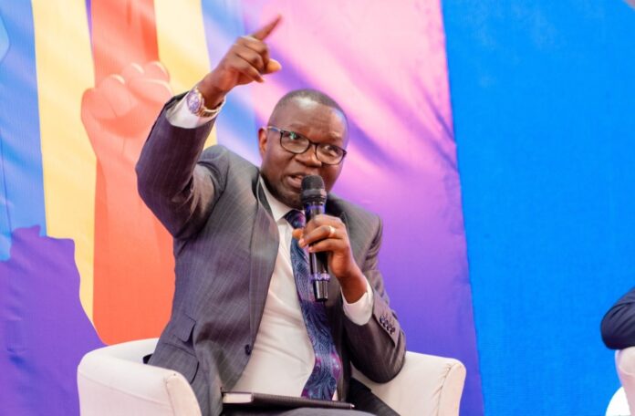 Drapeaux de la RDC et du Royaume-Uni sur une table de conférence avec micros lors du prélancement du forum économique à Kinshasa