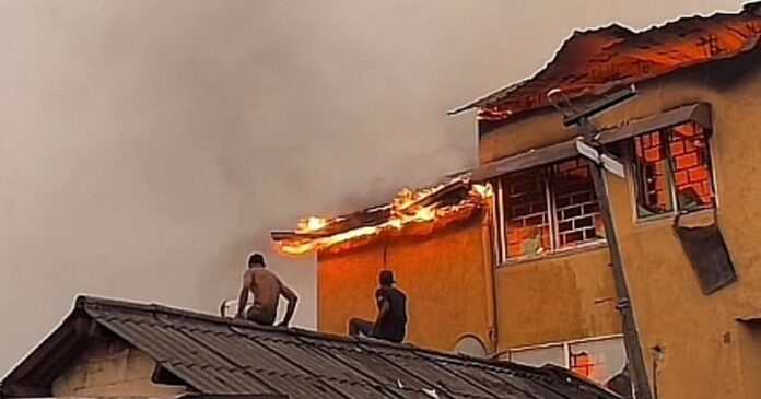 Maison en feu à Barumbu, Kinshasa, avec des flammes sortant des fenêtres