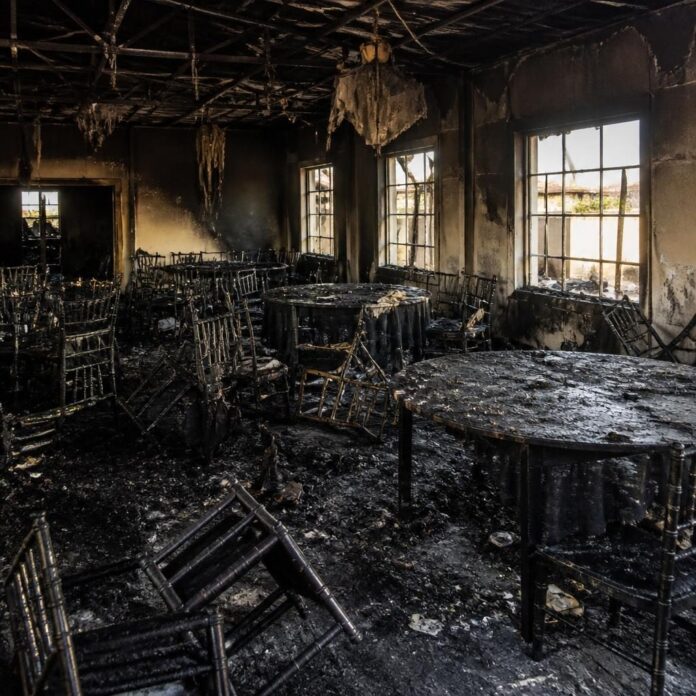 Intérieur d'une salle de fête détruite par un incendie à Kinshasa avec des débris et des traces de fumée