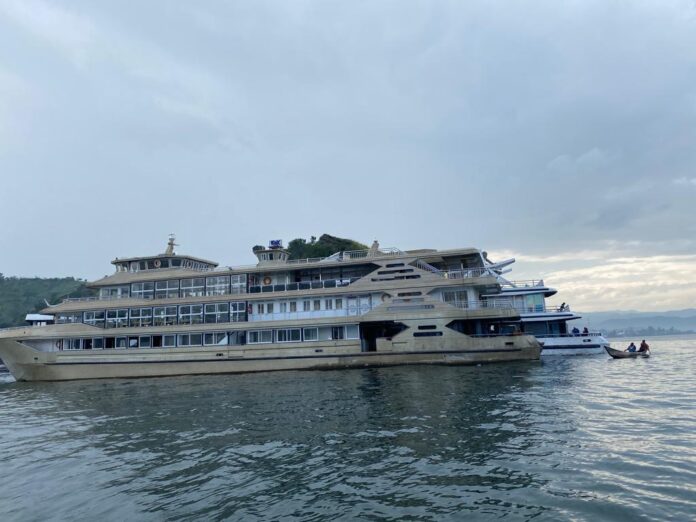 Navire de charge en feu dans un port sur le lac Tanganyika, dégageant une épaisse fumée noire