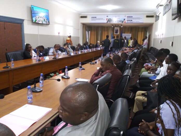 Salle de réunion à Matadi avec documents officiels et motifs culturels kongo lors de la signature d’une convention