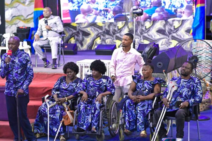 Femmes handicapées de la REPHADE remettant une vache au prophète Jules Mulindwa à la Cité de Refuge