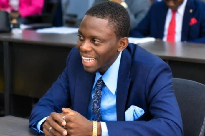 Documents juridiques, copie non lisible de la Constitution et micro posés sur un bureau, évoquant un débat constitutionnel à Kinshasa