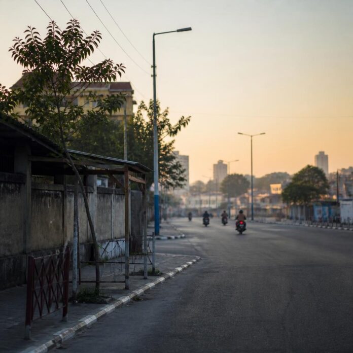 Écoliers avec cartables marchant dans une rue de Kinshasa au petit matin