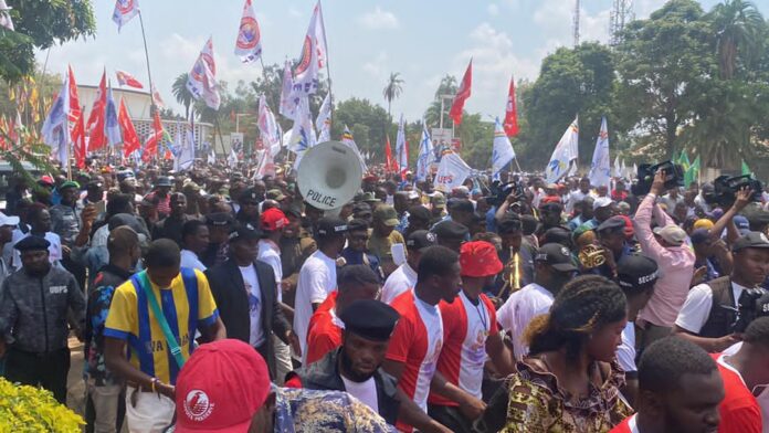 Policiers et véhicules de maintien de l’ordre déployés sur une avenue de Lubumbashi, devant des barrières métalliques