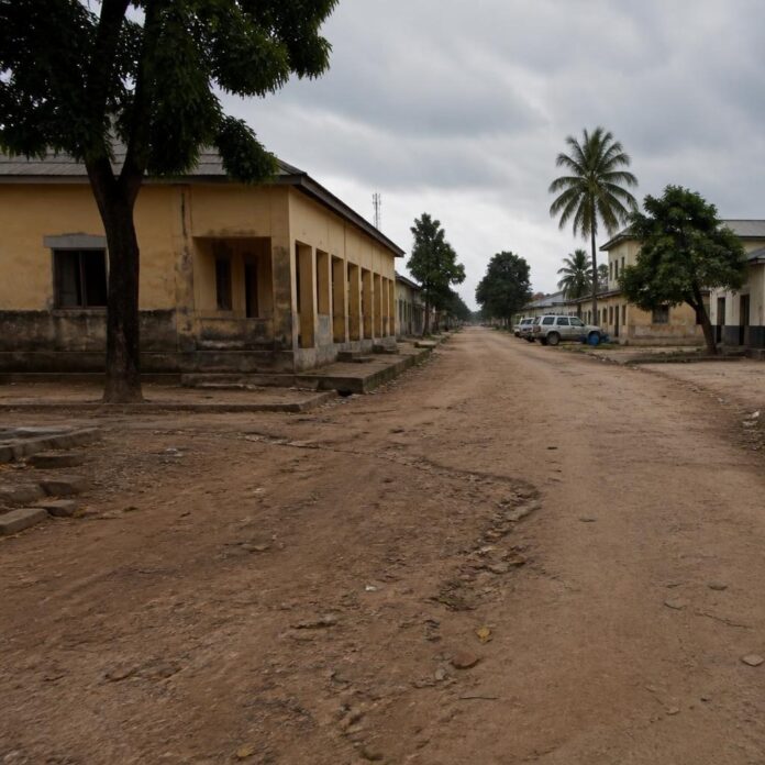 Rue principale de Luebo avec des bâtiments administratifs et des habitants vaquant à leurs activités