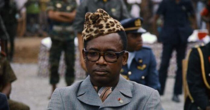 Salle de cinéma à Kinshasa avec un écran diffusant une image floue de motif léopard lors d'une commémoration