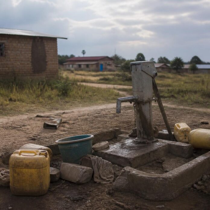 Femmes avec des récipients d'eau sur un sentier vers une rivière à Mupompa