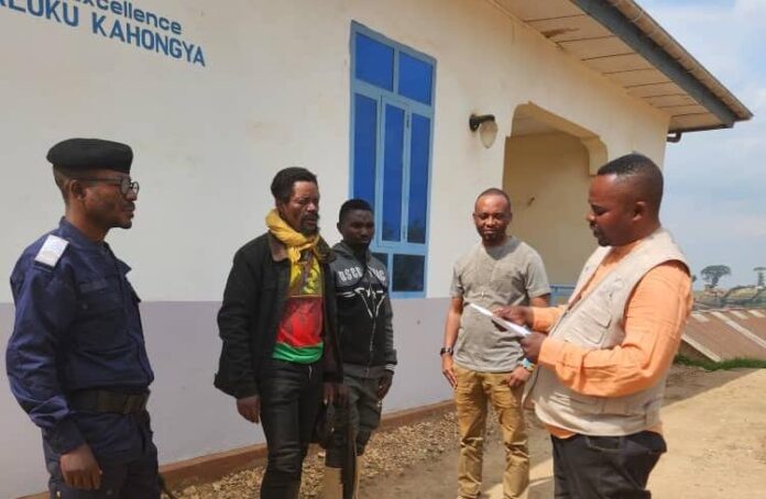 Deux combattants wazalendo remettent deux fusils AK-47 à un agent du PDDRC-S à Kipese, Lubero