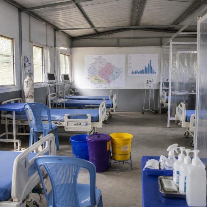 Salle de traitement Ebola avec équipements de protection, désinfectants et courbe épidémiologique affichée au mur