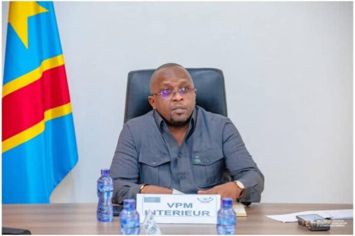 Table de réunion avec documents, carte de l'Est de la RDC et drapeau national dans un contexte administratif