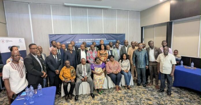 Salle de conférence avec tables et documents lors d'un atelier sur la résilience sanitaire à Kinshasa