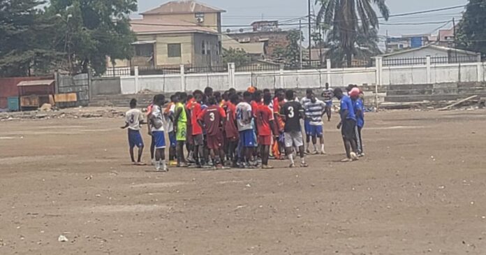 Terrain de football abîmé avec plots et ballons lors d'une séance d'entraînement à Kinshasa