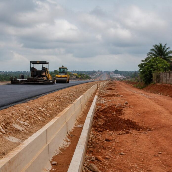Tronçon en construction de la Rocade de Kinshasa avec engins et caniveaux en béton