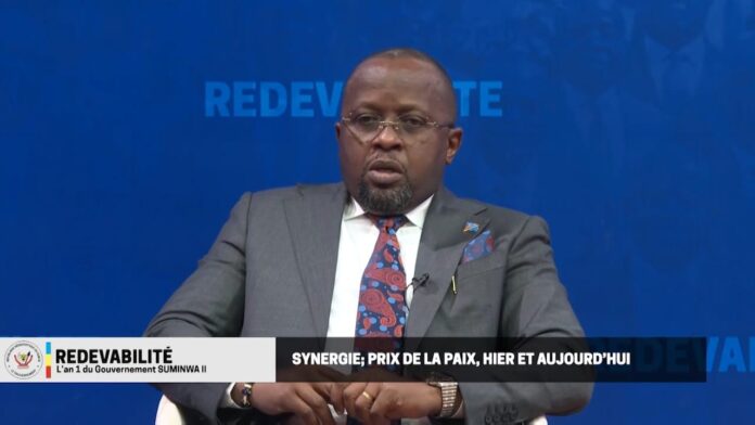 Tribune officielle à Kinshasa avec micros, dossiers et insignes de la police