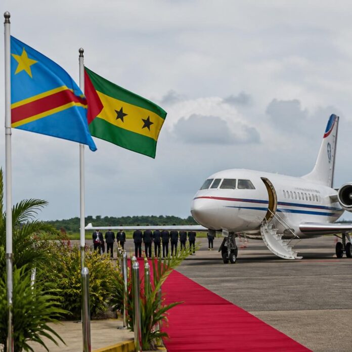 Tarmac d'un aéroport à São Tomé avec un avion présidentiel et des drapeaux congolais et santoméens