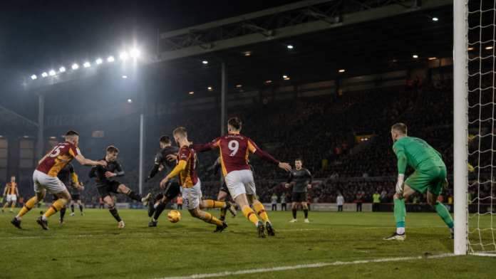 Joueurs anonymes en action lors d’un match de football anglais nocturne