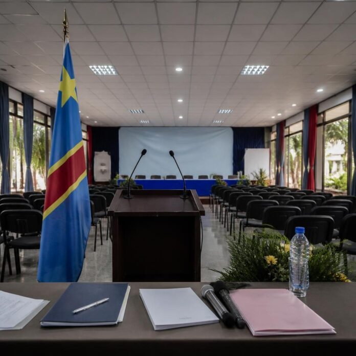 Des participants à une assemblée citoyenne à Kinshasa, avec des drapeaux congolais, lors du lancement de la Dynamique 52