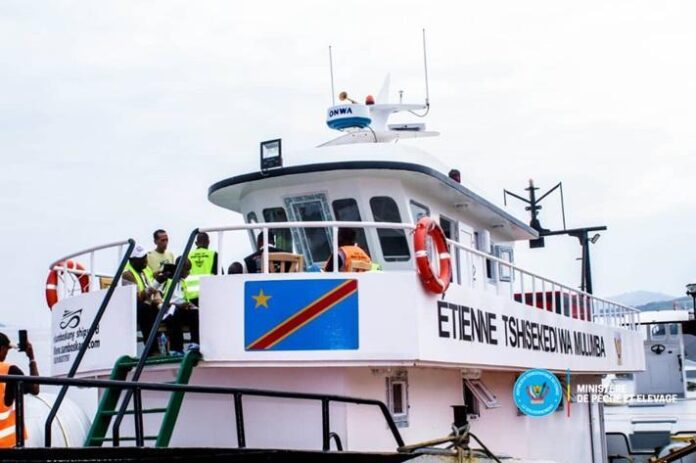 Vue d’un port de pêche avec plusieurs bateaux amarrés, sous un ciel gris, évoquant les infrastructures de la côte maritime congolaise
