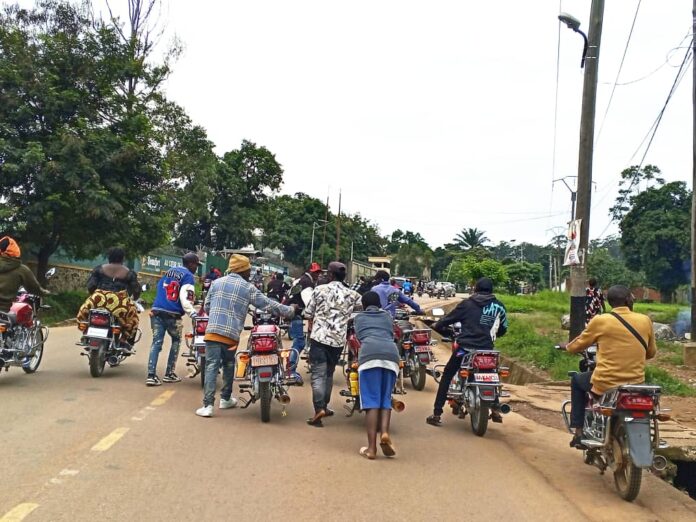 Longue file de camions-citernes stationnés près du poste frontalier de Kasindi, sous un ciel couvert