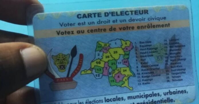 Bureau de la CENI à Kinshasa avec des cartes d’électeur et des documents électoraux sur une table