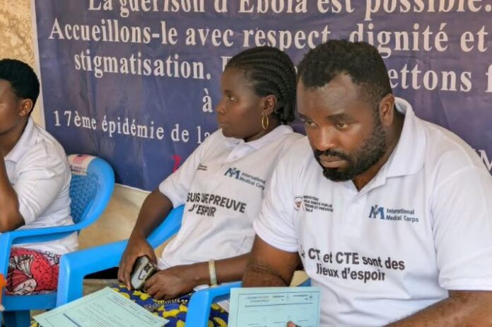 Soignants en tenue de protection devant le centre de traitement Ebola de Beni, ambiance de sortie de patients guéris