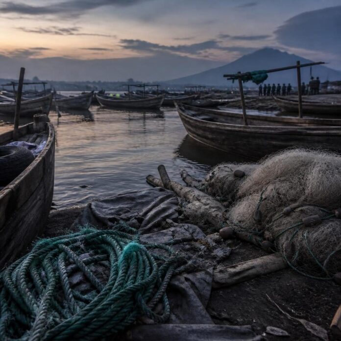 Eaux du lac Kivu près du port de Goma avec barques et cordes sur la rive