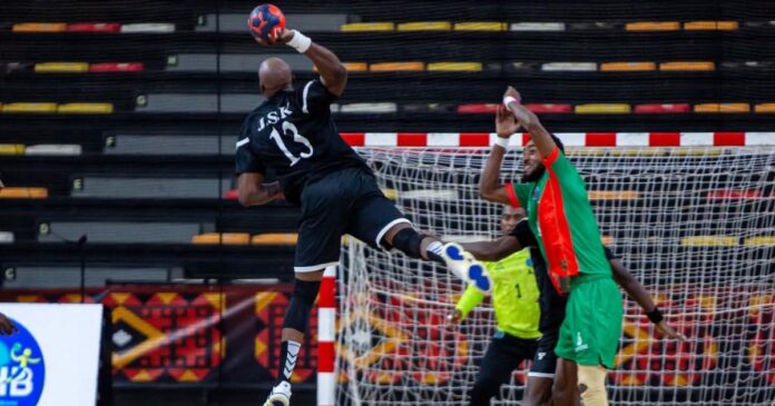 Action de handball entre deux clubs africains dans une salle de Luanda, avec la JSK en possession du ballon