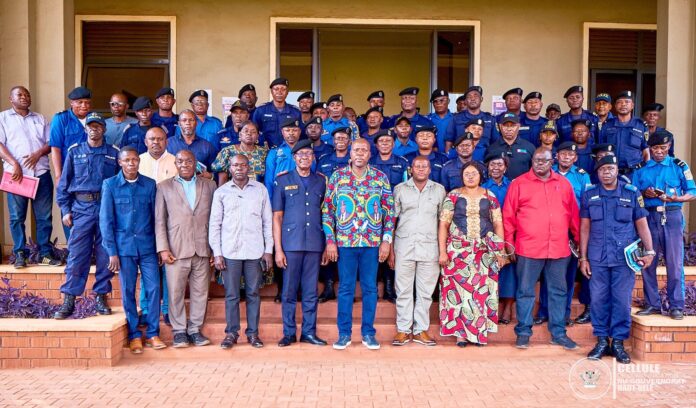Salle de réunion officielle à Isiro avec responsables de sécurité, policiers et dossiers judiciaires